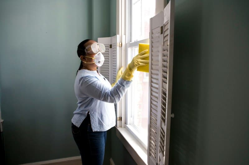 Cleaner wiping kitchen surfaces in a bright home